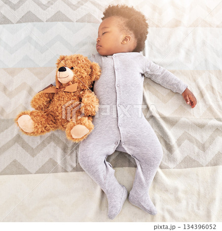 Top view, teddy bear and baby sleeping in bed for rest, nap time and dreaming in nursery. Childcare, newborn and cute, tired and African child with toy in bedroom sleep for comfort, relax and calm 134396052