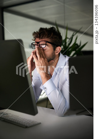 Tired, night and a businessman with a headache at work, deadline burnout and frustrated. Stress, problem and a corporate employee in a dark office with anxiety or depression from an email on a pc 134396096