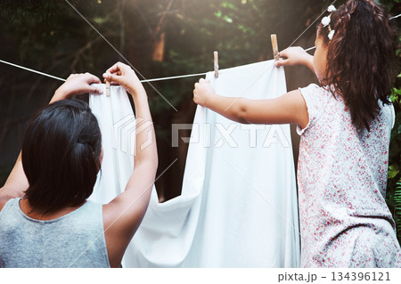 Help, hanging laundry and a mother and child doing housework, chores and busy with clothes. Cleaning, family and back of a little girl helping mom with clothing on the line in the backyard together Help, hanging laundry and a mother and child doing housework, chores and busy with clothes. Cleaning, family and back of a little girl helping mom with clothing on the line in the backyard together 134396121