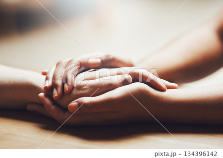 Prayer, empathy and support with people holding hands in comfort, care or understanding on a wooden table of a home. Love, faith or depression with friends closeup for help, hope or peace for healing 134396142