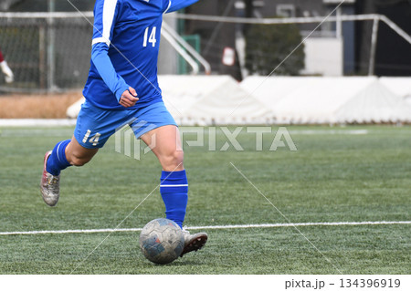 ドリブルするサッカー選手 134396919