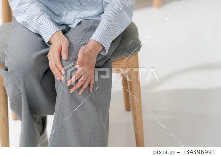 膝を押さえる女性 134396991