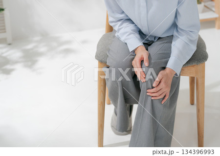 膝を押さえる女性 134396993