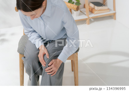 膝を押さえる女性 134396995