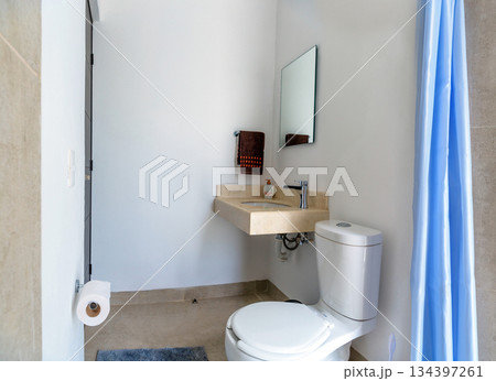 modern bathroom with blue shower curtain and white decor 134397261