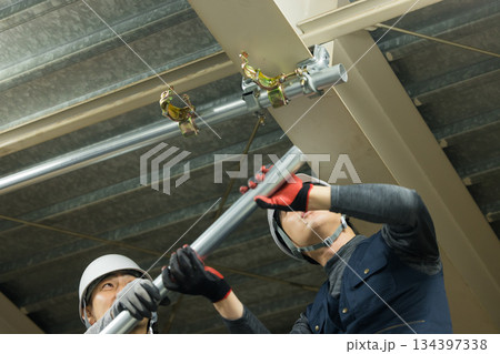 工場現場で単管パイプを組む作業員 134397338