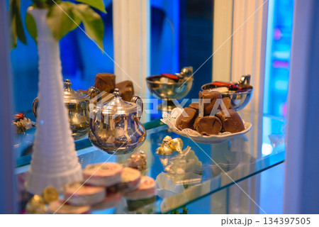 vintage dessert table with cookies chocolates and pink roses 134397505