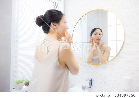 洗面所で鏡を見る若い女性 134397550