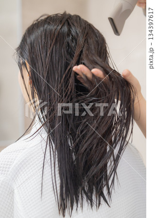 ドライヤーで髪の毛を乾かす若い女性 ドライヤーで髪の毛を乾かす若い女性 134397617
