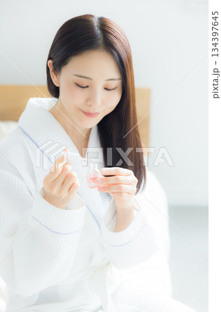 ベッドに座る女性　 134397645