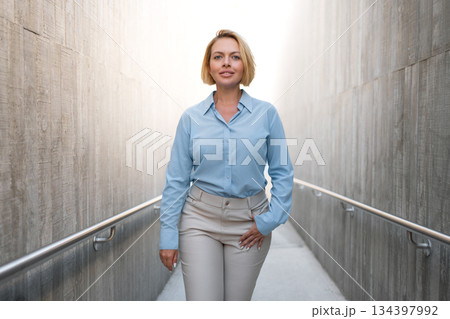 Confident businesswoman walking through modern 134397992
