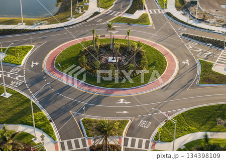 Traffic circle on American road with driving cars. Overhead view of US roundabout intersection Traffic circle on American road with driving cars. Overhead view of US roundabout intersection 134398109