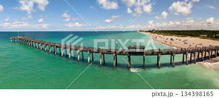 Summer landscape at Venice fishing pier in Florida. Ocean surf waves crashing on warm sandy beach 134398165