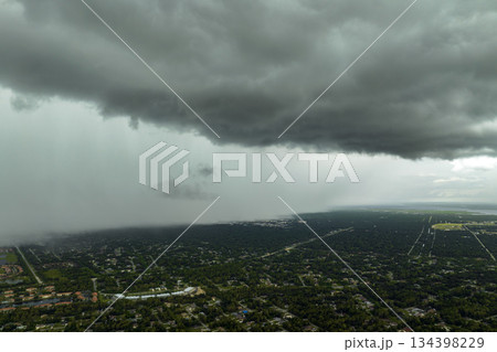 Rainstorm shower over Florida rural town in humid summer season. Rain water pouring down from stormy clouds 134398229