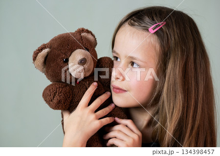 Pretty child girl playing with her teddy bear toy. Pretty child girl playing with her teddy bear toy. 134398457