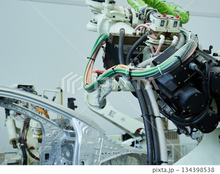 車の車体を溶接する現場で活躍する溶接ロボットの様子 134398538