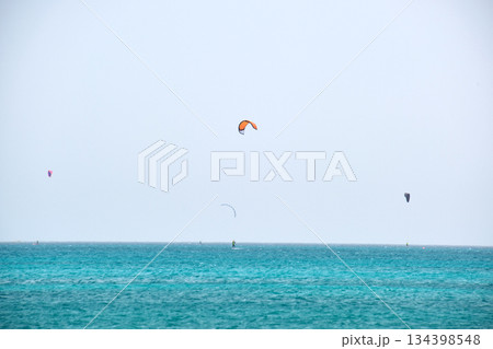People sportsmen windsurfing and kite surfing in blue ocean water. Summer extreme exotic sport concept 134398548