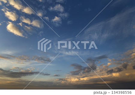 Panorama of sky at sunrise or sunset. Beautiful view of dark blue clouds lit by bright orange yellow sun on clear sky. Beauty and power of nature, meteorology and climate changing concept. Panorama of sky at sunrise or sunset. Beautiful view of dark blue clouds lit by bright orange yellow sun on clear sky. Beauty and power of nature, meteorology and climate changing concept. 134398556