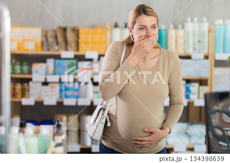 Pregnant woman visits pharmacy and suffers from nausea Pregnant woman visits pharmacy and suffers from nausea 134398639