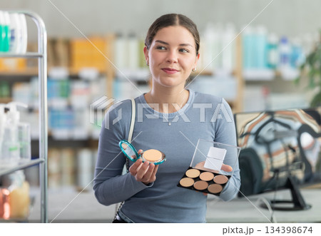 Young girl choosing cosmetics in chemist's shop 134398674