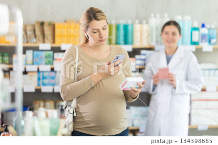 Pregnant woman buyer scans pills qr code with woman pharmacist Pregnant woman buyer scans pills qr code with woman pharmacist 134398685