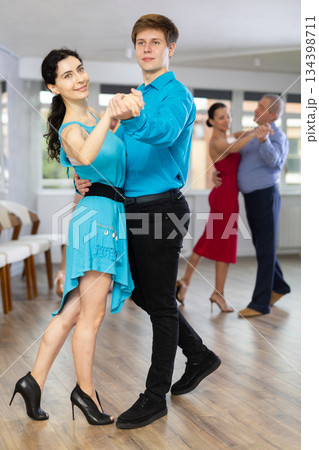Woman paired with male partner dance samba in dance class with students 134398711