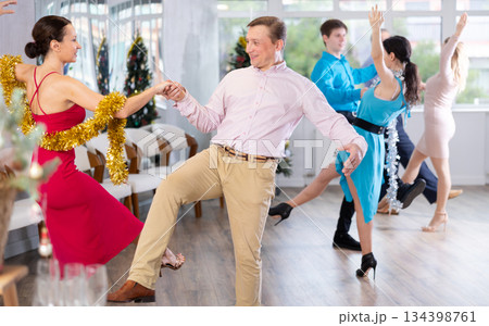 Lively adult couple dancing Lindy Hop at office New Year celebration Lively adult couple dancing Lindy Hop at office New Year celebration 134398761