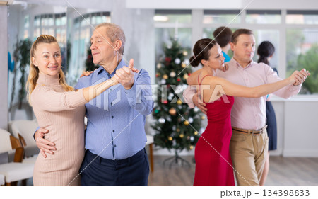 Elderly man dancing slow dance with woman during New Year corporate party 134398833