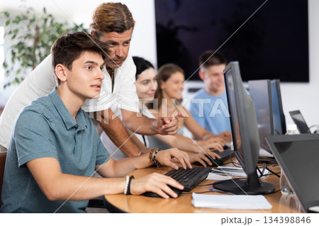 Motivated young trainee developer working at IT startup with mentor 134398846