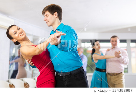 Pair dances - men and women in festive attire dance tango Pair dances - men and women in festive attire dance tango 134398997