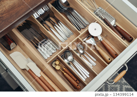 Bamboo organizer with cutlery in kitchen drawer 134399114