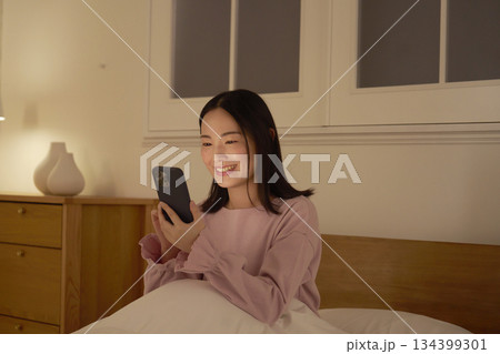 ベッドでスマホを使う女性 134399301