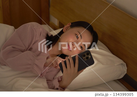 布団の中でスマホを使う女性 布団の中でスマホを使う女性 134399305