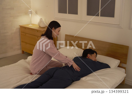 ベッドの上で夫をマッサージする妻 134399321