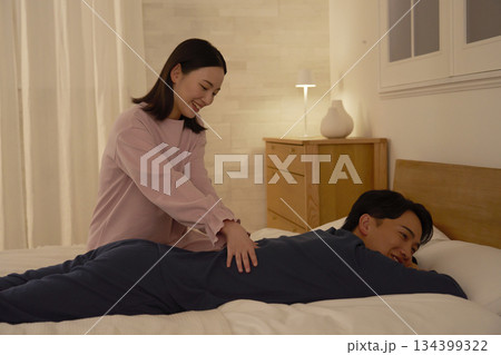 ベッドの上で夫をマッサージする妻 134399322