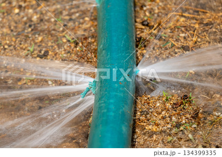 Water leaking from hole in a industrial hose. Water leaking from hole in a industrial hose. 134399335