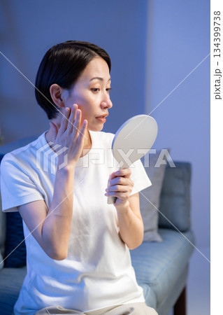手鏡を見て悩む女性 134399738