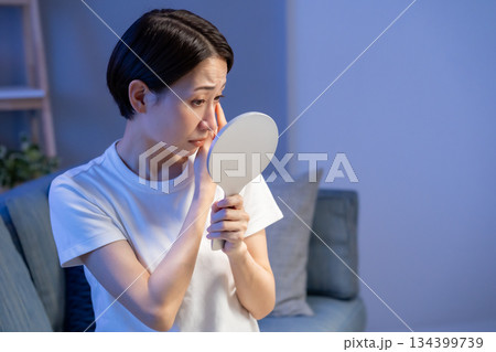手鏡を見て悩む女性 134399739