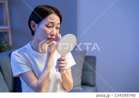 手鏡を見て悩む女性 134399740