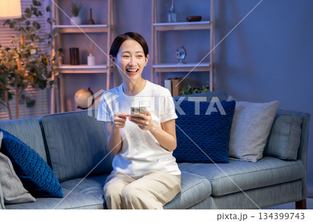 リビングでスマホを見る女性 134399743