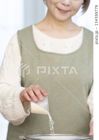 キッチンでご飯を炊く準備をするシニア女性の手元 134399776