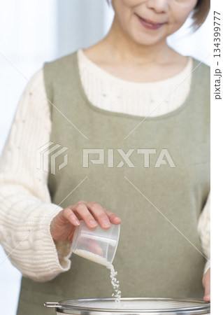 キッチンでご飯を炊く準備をするシニア女性の手元 134399777