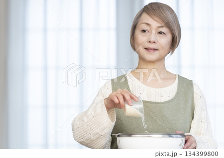 キッチンでご飯を炊く準備をするシニア女性 キッチンでご飯を炊く準備をするシニア女性 134399800