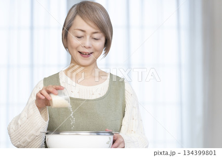 キッチンでご飯を炊く準備をするシニア女性 キッチンでご飯を炊く準備をするシニア女性 134399801