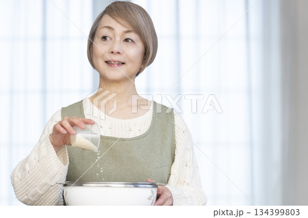 キッチンでご飯を炊く準備をするシニア女性 134399803