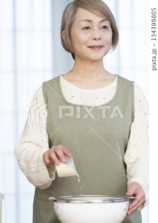 キッチンでご飯を炊く準備をするシニア女性 キッチンでご飯を炊く準備をするシニア女性 134399805