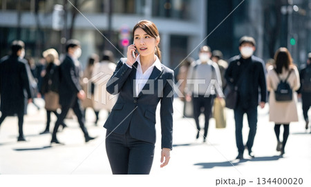 外出先で緊急の連絡を受けるビジネスウーマン　トラブル対応や真剣な商談のイメージ 134400020