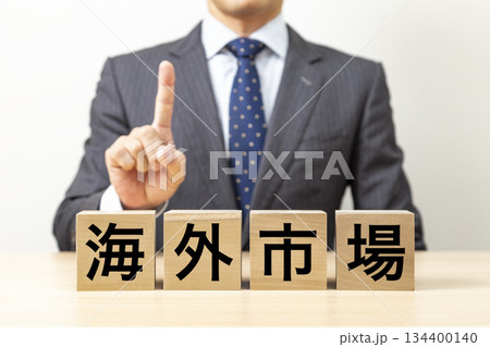 「海外市場」と書かれたブロックとビジネスマン 134400140