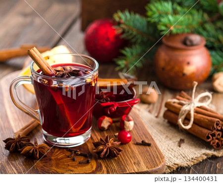 Hot Christmas mulled wine drink with fresh orange and spices in a glass cup on white 134400431