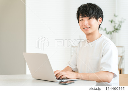 家のリビングでノートパソコンを使う若いアジア人男性（個人投資家,投資家,投資,資産運用） 134400565